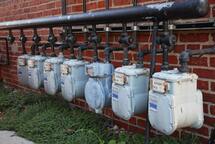 Ugly natural gas meters outside brick wall